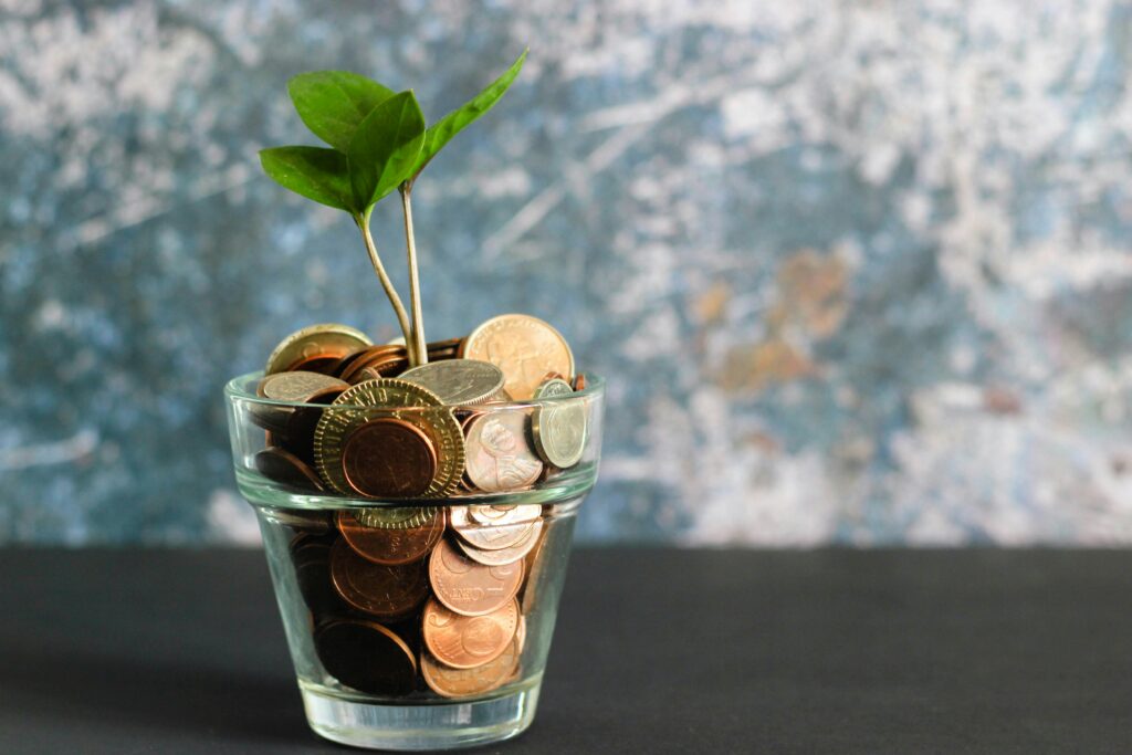 A plant growing out of a glass of coins