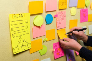 Closeup of blank plan sticky note and businessman making notes.Project planning with sticky notes