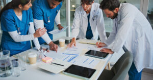 Doctor, people or meeting in hospital with paperwork for patient diagnosis, medical advice or planning. Nurse, healthcare team and conversation for research, documents and collaboration strategy.