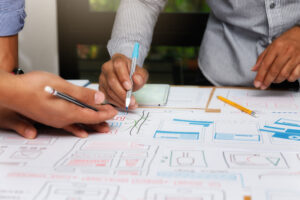 UX or UI designers designing on their smartphone application layout prototype project.