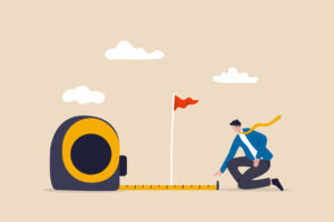 Business success measurement, how far from business goal and achievement or growth metric analysis concept, smart businessman using measuring tape to measure and analyze distance from target flag. Business success measurement, how far from business goal and achievement or growth metric analysis concept, smart businessman using measuring tape to measure and analyze distance from target flag.