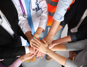 Portrait of people with various occupations putting their hands on top of each other Portrait of people with various occupations putting their hands on top of each other.
